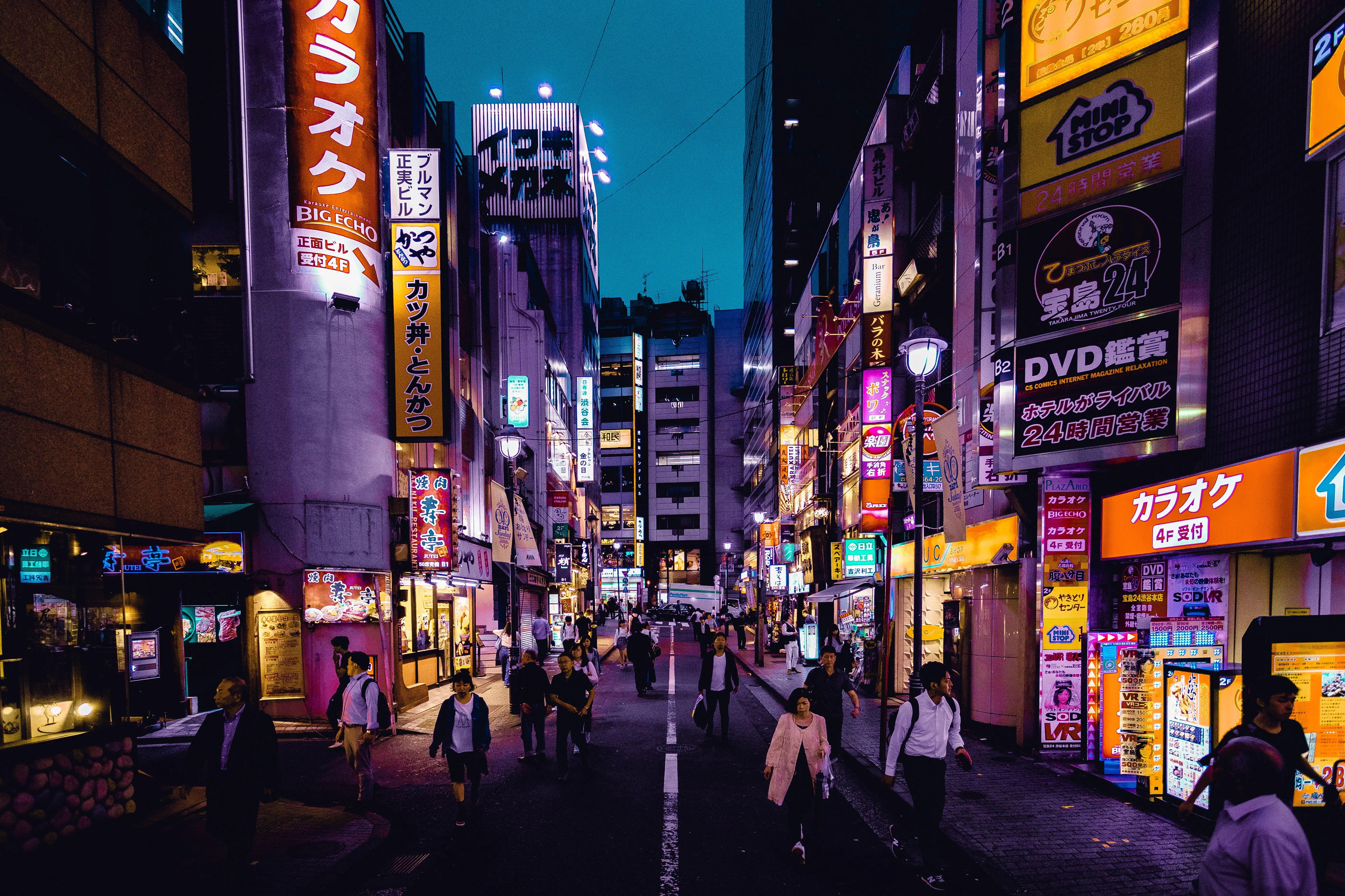 Een foto van een straat in japan met veel lichtgevende borden