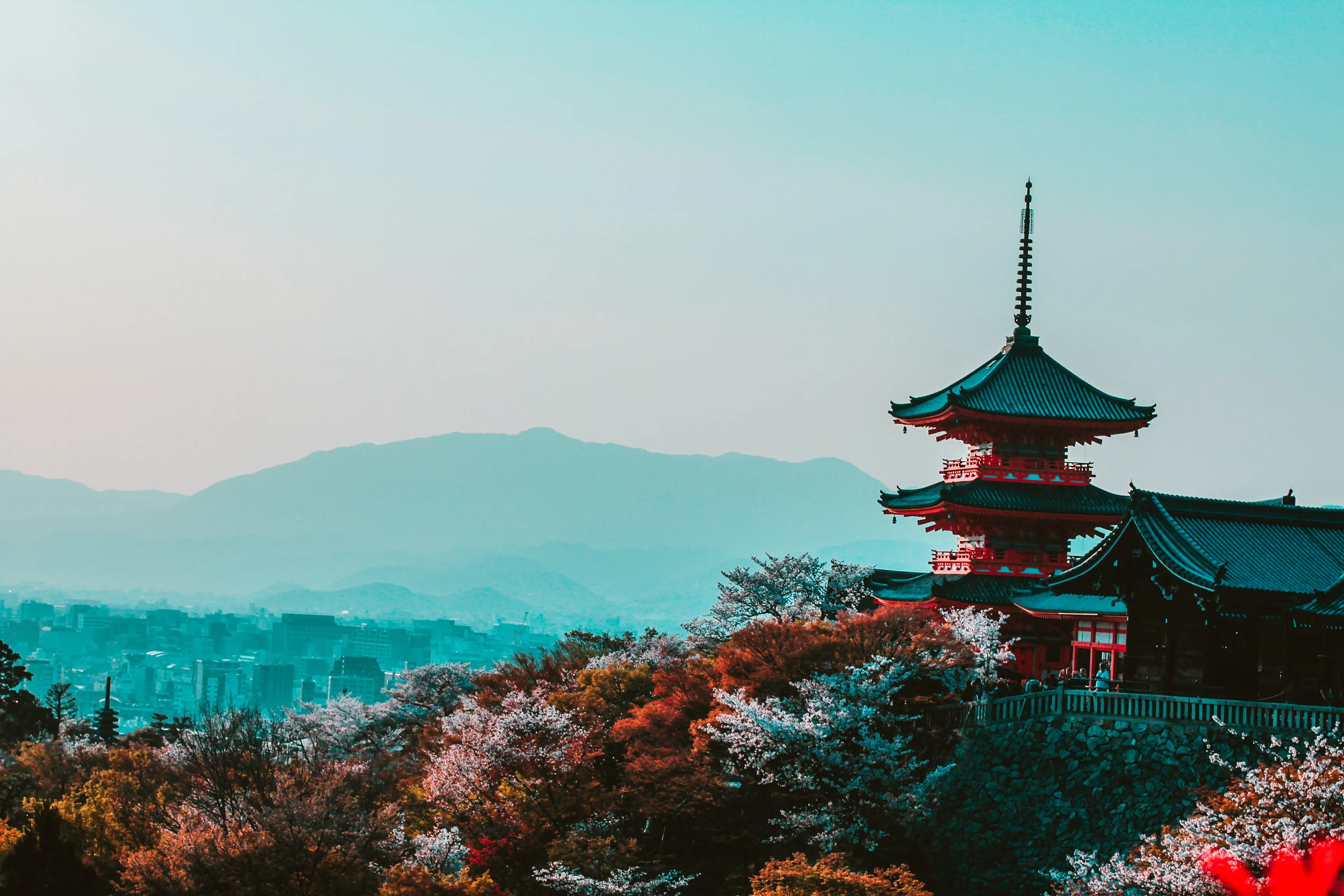 Een foto van een tempel in japan met op de achtergrond een japanse stad